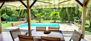 圣弗朗索瓦Cocooning Paradise的庭院内带桌椅的游泳池