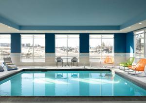 雷德蒙德Hampton Inn Redmond Bend Airport的游泳池位于酒店客房内,配有桌椅