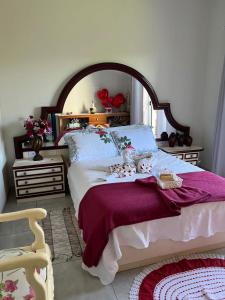 圣特雷济尼亚-迪伊泰普Jardim D’Jully的一间卧室配有一张大床和紫色毯子