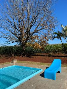 圣特雷济尼亚-迪伊泰普Jardim D’Jully的游泳池旁的蓝色长椅