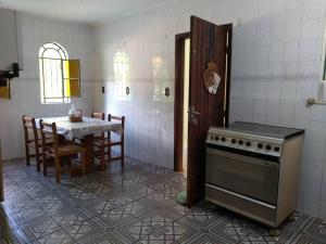 迈里波朗Chácara dos Sonhos em Mairiporã的厨房配有桌子和炉灶。