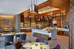 沙迦DoubleTree by Hilton Sharjah Waterfront Hotel And Residences的厨房以及带桌椅的用餐室。