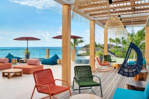 马累Hilton Maldives Amingiri Resort & Spa的一个带椅子和秋千的庭院和大海