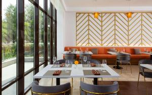 奇姆肯特DoubleTree by Hilton Shymkent的用餐室设有桌椅和窗户。