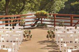 格雷普韦恩希尔顿DFW湖行政会议中心的婚礼过道,带白色椅子和盆栽植物