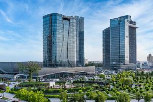 塔什干Hilton Tashkent City的一座公园里两座高楼