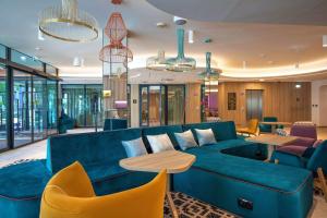 比亚韦斯托克Hampton By Hilton Bialystok的客厅配有蓝色的沙发和桌椅