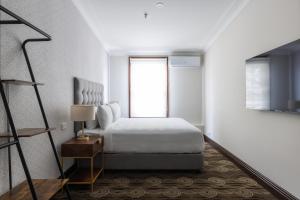 悉尼南十字星酒店的白色的卧室设有床和窗户