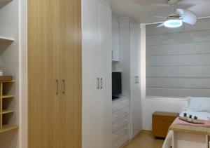 坎皮纳斯Studio completo com vaga entre o Centro e Cambuí的一间厨房,配有白色橱柜和一台电视机