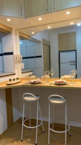坎皮纳斯Studio completo com vaga entre o Centro e Cambuí的厨房配有2张凳子和酒杯