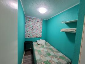 科皮亚波Atacama Valley 6的小房间设有床和蓝色的墙壁