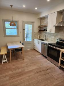 蒙特利尔Elegant two bedroom with office in Montreal的厨房配有白色橱柜、桌子和水槽。