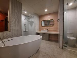 釜山Rein Hotel Busan Yeonsan的带浴缸、盥洗盆和卫生间的浴室