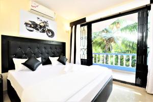 巴加Private Villa in Arpora的卧室配有一张床,墙上挂着摩托车