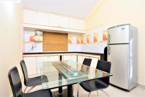 巴加Private Villa in Arpora的厨房配有玻璃桌和冰箱