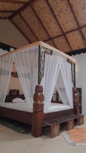武吉拉旺Jungle Inn Bukit lawang的一张木床,上面有窗帘