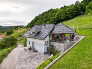 斯玛杰克托莱塞Holiday home in Smarjeske Toplice - Kranjska Krain 45723的山坡上白色的房子,有板岩屋顶