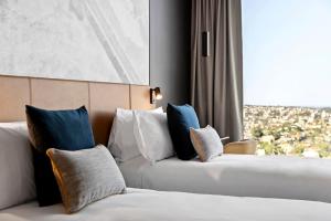 悉尼Citadines Walker North Sydney的酒店客房设有两张床和窗户。