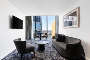 悉尼Citadines Walker North Sydney的客厅配有沙发、椅子和桌子