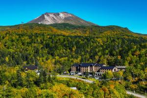 东川町Higashikawa Asahidake Onsen Hotel Bear Monte的远方的山,前方的建筑