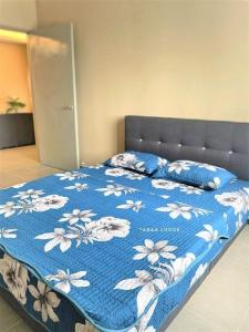 普特拉贾亚Taraa Lodge PutrajayaMuslim的一张床上,床上有鲜花,有蓝色的毯子