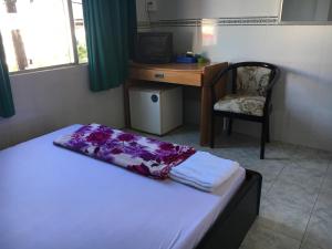 金瓯Khách sạn Thiên Phúc的一间卧室配有一张床、一张桌子和一把椅子