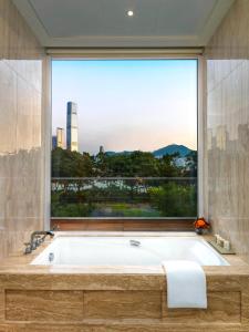 香港遨凯酒店的带浴缸的浴室和大窗户