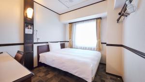 成田Toyoko Inn Narita Airport Shinkan的小房间设有床和窗户