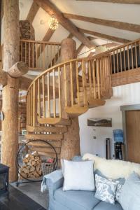 威廉堡Wild Nurture Eco Luxury Offgrid Log Cabin的客厅设有蓝色的沙发和木制楼梯。