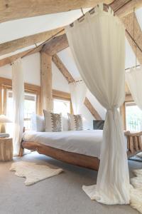 威廉堡Wild Nurture Eco Luxury Offgrid Log Cabin的一间卧室配有一张带窗帘的大床