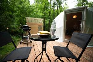 赛维尔维尔Solace glamping的木甲板上的桌椅和帐篷