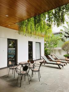 会安Hoianese Hotel - Lip Lip Pool Villa的庭院里设有桌椅。