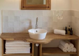 威廉堡Wild Nurture Eco Luxury Offgrid Log Cabin的一间带水槽和桌子毛巾的浴室