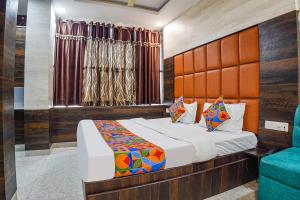 NaiāpuraFabHotel Brij Residency的一间卧室配有一张床和一张蓝色椅子