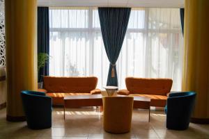 科瓦斯纳Complex Balnear Covasna的客厅配有2把橙色椅子和桌子