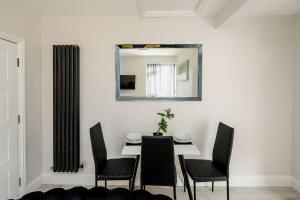 米查姆CommonSide Luxury的一间带桌椅和镜子的用餐室