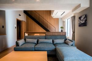 东川町Higashikawa Asahidake Onsen Hotel Bear Monte的客厅配有蓝色的沙发和木桌