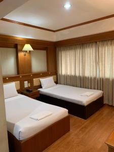 色军帝国沙康酒店的酒店客房设有两张床和窗户。