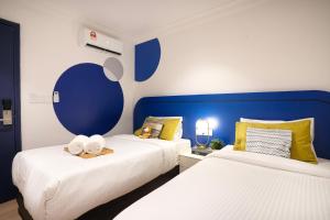 八打灵再也Ukiyo Hotel的蓝色和白色的客房内的两张床