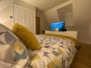 斯托昂泽沃尔德The Cotswold Stowaway, Perfect Luxurious Retreat!的一间卧室配有一张床,墙上配有电视