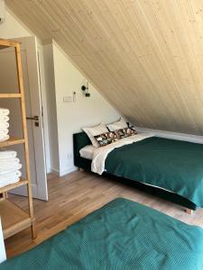 加茨比亚格拉Morze Brzoza的一间卧室设有绿色的床和木制天花板