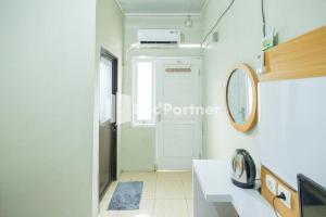 西冷Atiq Homestay Syariah Mitra RedDoorz的一间带水槽、镜子和门的浴室