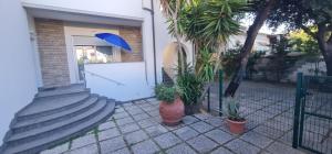 圣温琴佐Lecci al Mare的白色门和蓝色伞的房子