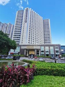 深圳深圳中洲圣廷苑酒店世纪楼, 华强北商圈的一座大型建筑,前面有汽车停放