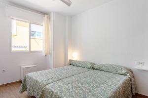 马拉加Casa Mar de frente的白色的卧室设有床和窗户
