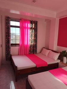 碧瑶EMILIEZ PLACE的一间卧室配有两张床和粉红色窗帘