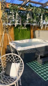 BallymaganThe Garden Pod with Private Hot Tub的浴缸,花挂在凉棚上