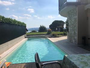 科麦里奥Villa Sasso Il Bianco Varese Lake的庭院内的游泳池,配有桌椅