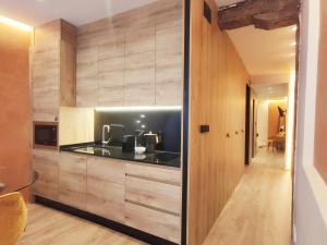 毕尔巴鄂Apartamento Boutique Casco Viejo的厨房配有木制橱柜和黑色台面