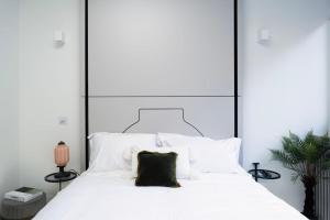 哈罗Spacious Studio Apartments at Dandi on The Hill的一间卧室配有一张白色大床和黑色床头板